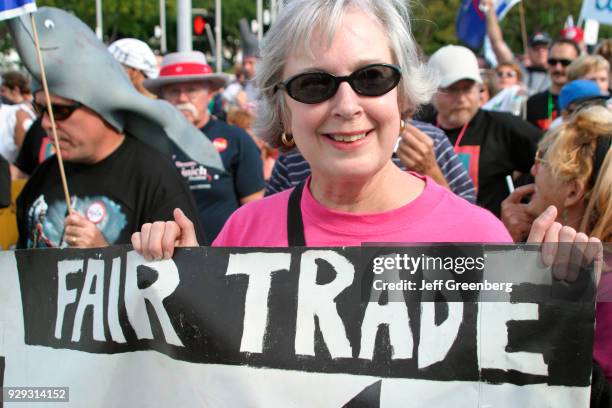 Protester holding a banner at the Free Trade Area of Americas Summit on Biscayne Boulevard.