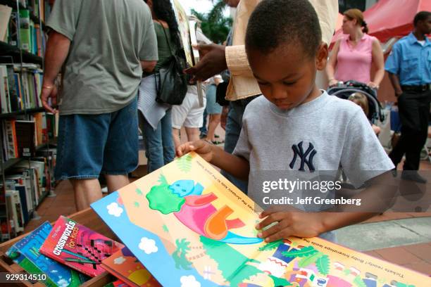 Boy looking at a book at the International Book Fair at Wolfson Campus.