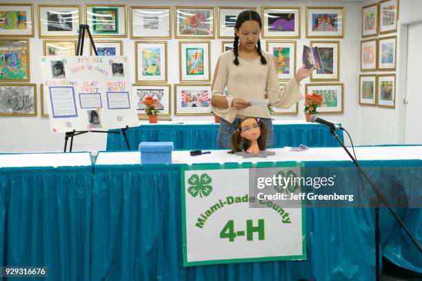 Teen girl makes a hairstyling presentation at the 4-H Club public speaking competition at Miami-Dade County Fair.