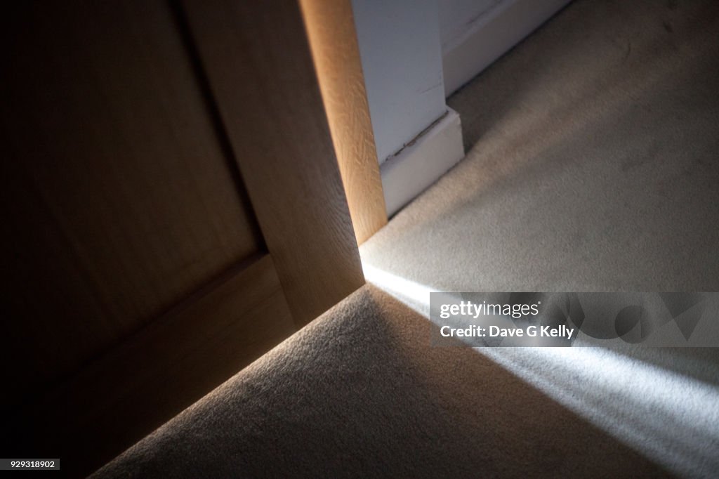 Sunlight falling on floor through A Door Ajar