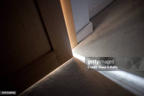 sunlight falling on floor through a door ajar - doors of the 21st century ストックフォトと画像