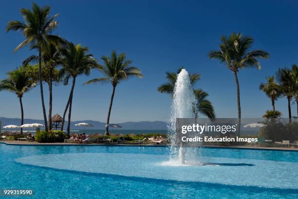 Pool with fountain at Nuevo Vallarta Mexico with Palm trees and vacationers.