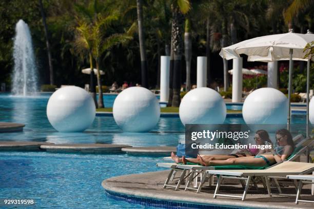 Two young woman lounging by the pool in Nuevo Vallarta Mexico.