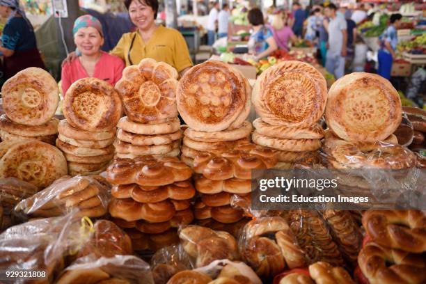 Shop keepers in Shymkent Central Market next to table of Kazakh Tandyr nan breads Kazakhstan.