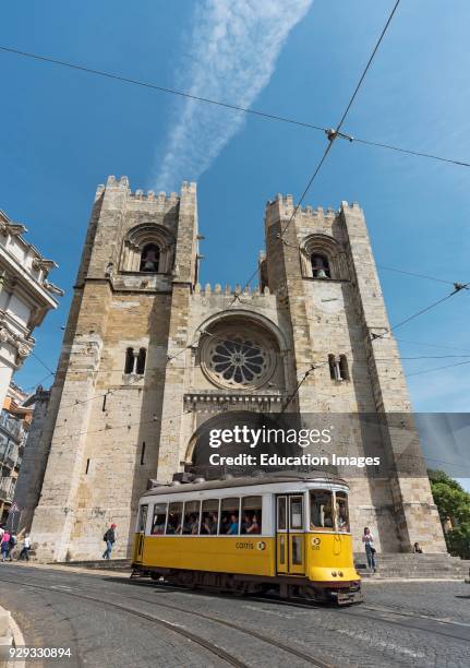 Tram passes by Lisbon Cathedral , Portugal.