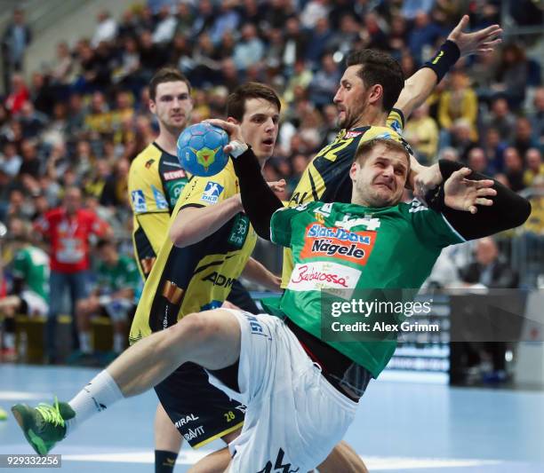 Kresimir Kozina of Goeppingen is challenged by Alexander Petersson and Hendrik Pekeler of Rhein-Neckar Loewen during the DHL HBL match between...