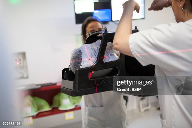 Radiotherapy unit of hospital, Savoie, France, Radiotherapy session to treat metastases of the brain. A mask is placed over the patient in order to...