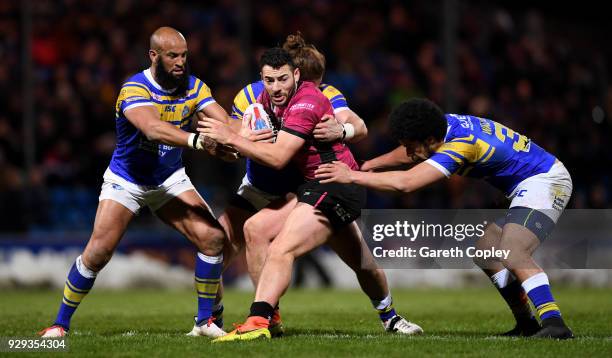 Jake Connor of Hull FC is tackled by Jamie Jones-Buchanan, Anthony Mullally and Josh Walters of Leeds during the Betfred Super League match between...