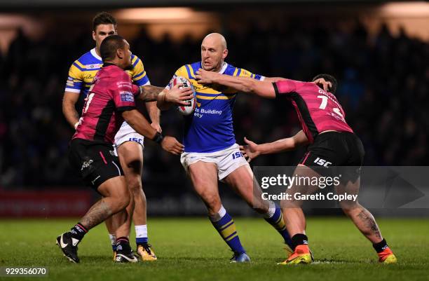 Carl Ablett of Leeds is tackled by Sika Manu and Mark Minichiello of Hull FC during the Betfred Super League match between Leeds Rhinos and Hull FC...