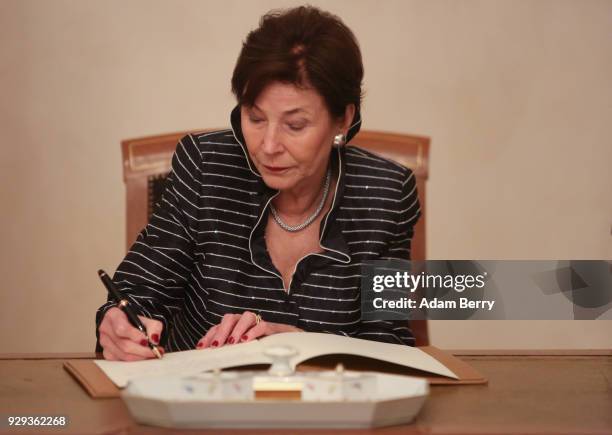 Former German President Horst Koehler's wife Eva Luise Koehler signs a guest book at a dinner in her husband's honor during his 75th birthday at...