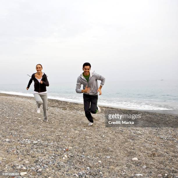 Couple Running On Beach.