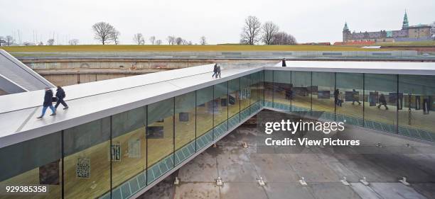 Danish Maritime Museum , Helsingor, Denmark. Architect: Bjarke Ingels Group , 2013. Elevated view of sloping ramps, dry dock and glazed walkway...