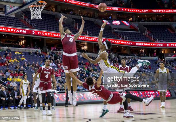 George Mason Patriots forward AJ Wilson gets in a shot between Massachusetts Minutemen guard Luwane Pipkins and forward Malik Hines during a second...