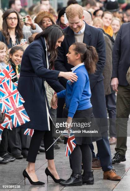 Meghan Markle and Prince Harry greet a school girl as they visit Millennium Point on March 8, 2018 in Birmingham, England.