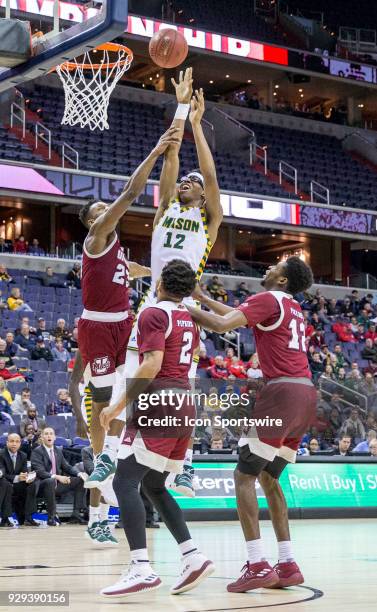 George Mason Patriots forward AJ Wilson rises above Massachusetts Minutemen guard C.J. Anderson to tip in a basket during a second round game of the...