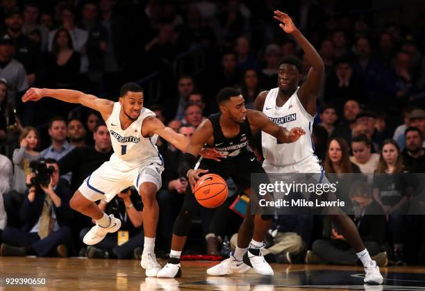 Kyron Cartwright of the Providence Friars handles the ball against Davion Mintz and Khyri Thomas of the Creighton Bluejays in the second half during...