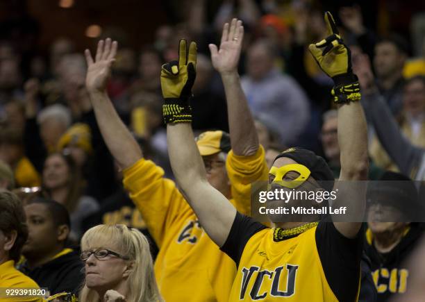 Virginia Commonwealth Rams fans hold their hands in the air against the Dayton Flyers in the second round of the Atlantic 10 basketball tournament at...