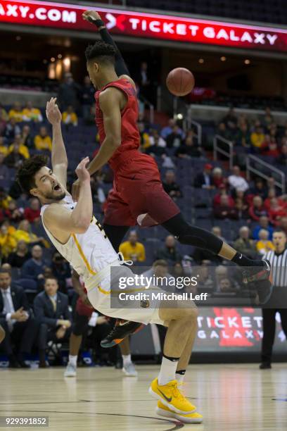 Darrell Davis of the Dayton Flyers charges into Sean Mobley of the Virginia Commonwealth Rams in the second round of the Atlantic 10 basketball...