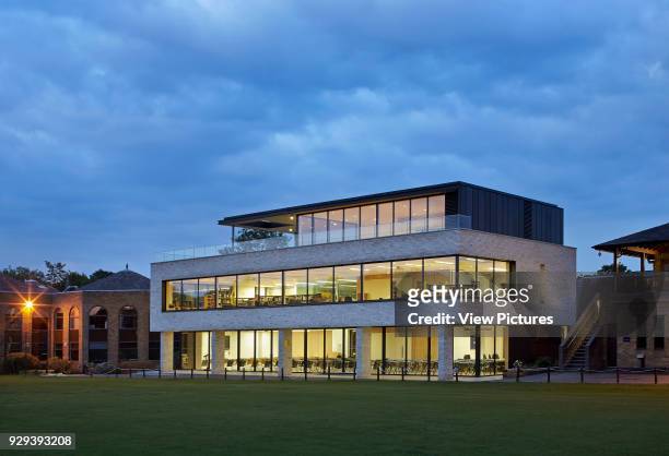 Oblique dusk elevation with illuminated interiors. The Martin Centre, Forest School, London, United Kingdom. Architect: BuckleyGreyYeoman, 2014.
