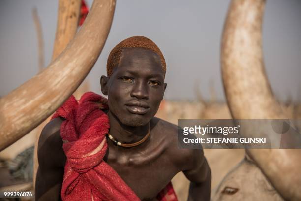 Sudanese man from Dinka tribe shows his orange hair bleached by cow's urine at their cattle camp in Mingkaman, Lakes State, South Sudan, on March 3,...