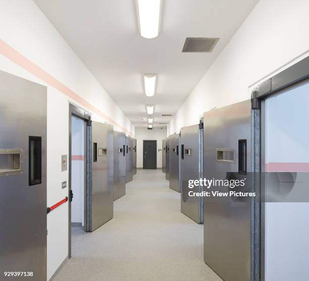 Hallway with custody cells to both sides. Keynsham Custody Suite and Prosecution and Investigation Facility, Keynsham, United Kingdom. Architect:...