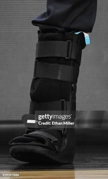 Head coach Tad Boyle of the Colorado Buffaloes wears a walking boot during a quarterfinal game of the Pac-12 basketball tournament against the...