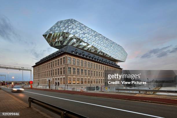 Contextual view from street at dusk. Port House, Antwerp, Belgium. Architect: Zaha Hadid Architects, 2016.