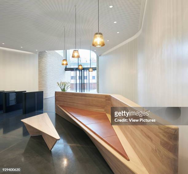 Wooden reception desk with integrated bench. Turnmill Building, London, United Kingdom. Architect: Piercy & Company, 2015.