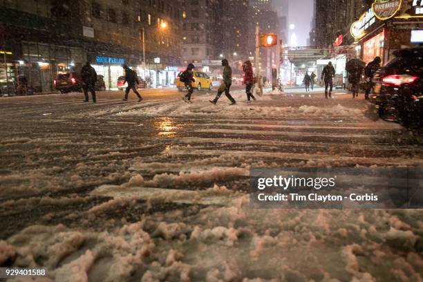 Commuters navigate the deluge from Winter Storm Quinn near Time Square, Manhattan, New York on March 7, 2018 New York City.