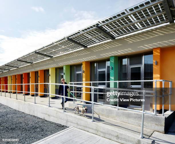 Oblique elevation of color coded facade with photovoltaic canopy and ramp. Battersea Dogs & Cats Home, London, United Kingdom. Architect: Jonathan...