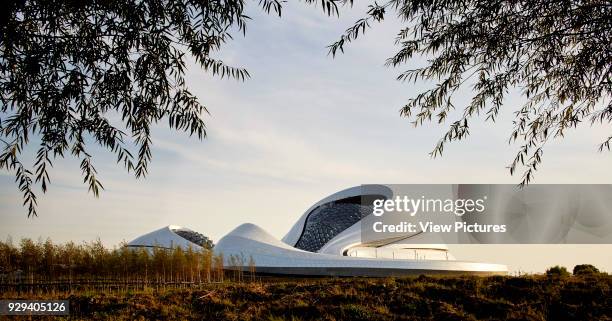 Distant view towards opera across wetland. Harbin Opera House, Harbin, China. Architect: MAD Architects, 2015.