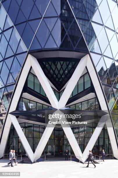 Iconic Entrance to the Gherkin with office workers passing by. Office Space at The Gherkin, London, United Kingdom. Architect: IOR GROUP Interiors,...