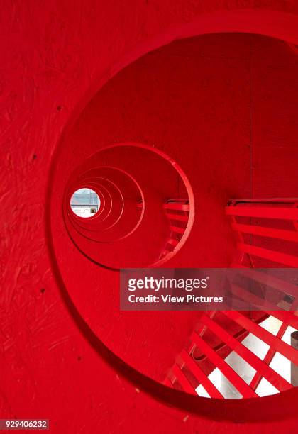 View looking through portholes punctuating the walls and dividing the bench seating. Big Red Pavilion, London, United Kingdom. Architect: Clancy...