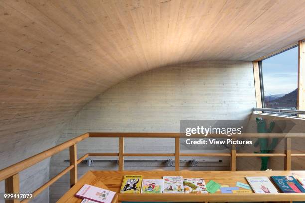 Children's reading area with arched shuttered concrete ceiling and view to valley.