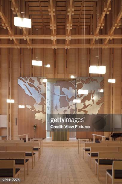 Viikki Church, Helsinki, Finland. Architect: JKMM Architects, 2005. Interior in spruce, with aisle flanked by pews leading to Elaman puu altarpiece...