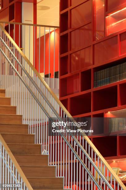 Main staircase against multi-storey red bookcase.