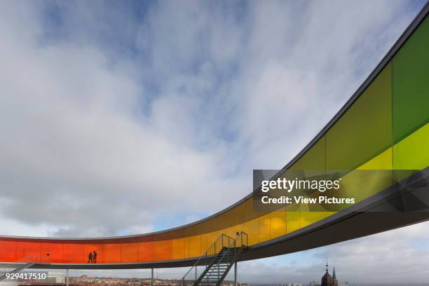 Your Rainbow Panorama' circular aerial walkway with cityscape beyond and silhouetted figures. ARoS Aarhus Kunstmuseum, Aarhus, Denmark. Architect:...