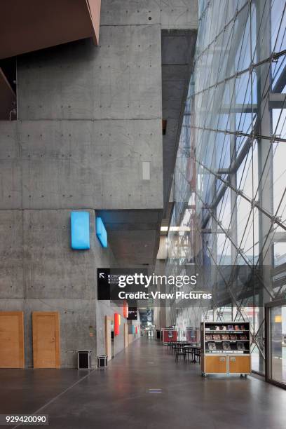 Lower level of foyer, with elephant skin concrete walls and diamond-pattern glass wall. DR Koncerthuset, Copenhagen, Denmark. Architect: Ateliers...