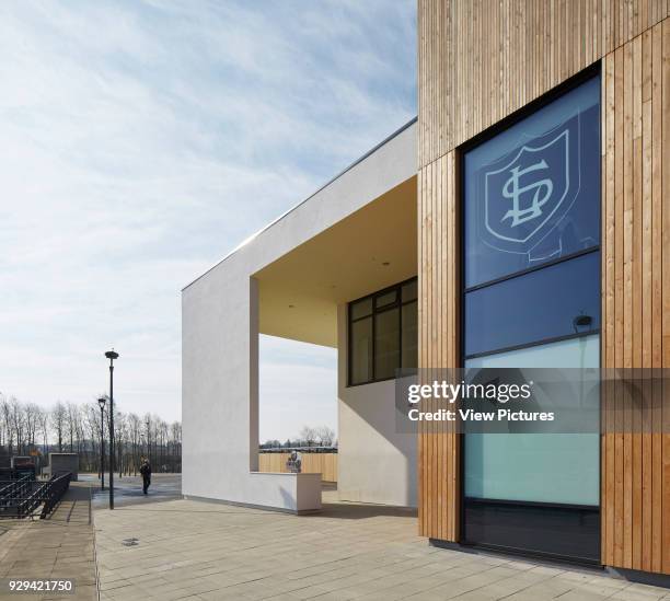 Larch clad main entrance with canopy and school's logo. Lairdsland Primary School, Kirkintilloch, United Kingdom. Architect: Walters and Cohen Ltd,...