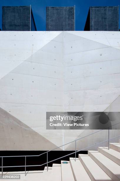 Juxtaposition of stairway with faceted concrete wall and skylights. Palacio da Justicia de Gouveia, Gouveia, Portugal. Architect: Barbosa &...