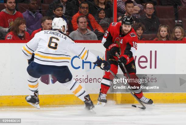 Zack Smith of the Ottawa Senators passes the puck against Marco Scandella of the Buffalo Sabres at Canadian Tire Centre on March 8, 2018 in Ottawa,...