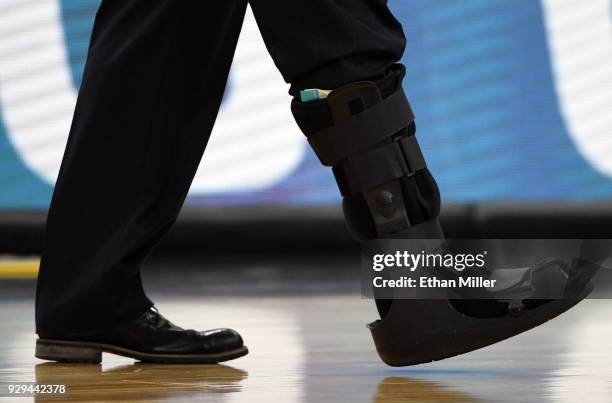 Head coach Tad Boyle of the Colorado Buffaloes wears a walking boot during a quarterfinal game of the Pac-12 basketball tournament against the...