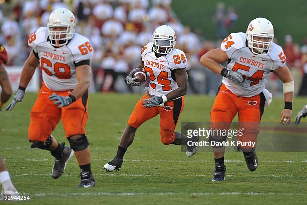 Running back Kendall Hunter of the Oklahoma State Cowboys rushes for yards up the middle with blocking help from teammates offensive lineman Lane...