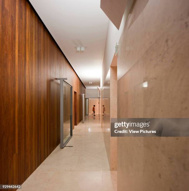 Perspective along courtroom corridor clad in dark timber. Palacio da Justicia de Gouveia, Gouveia, Portugal. Architect: Barbosa & Guimaraes, 2011.