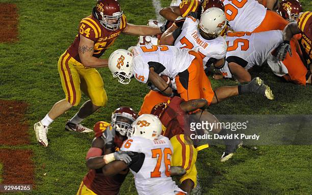 Running back Keith Toston of the Oklahoma State Cowboys jumps up and over Iowa State Cyclones defenders to score a touchdown in the 4th quarter of...