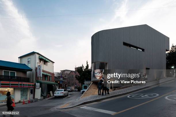 The Songwon Art Center embedded in its neighbourhood. Songwon Art Center / Bien-etre Restaurant, Seoul, Korea, South. Architect: Mass Studies, 2012.