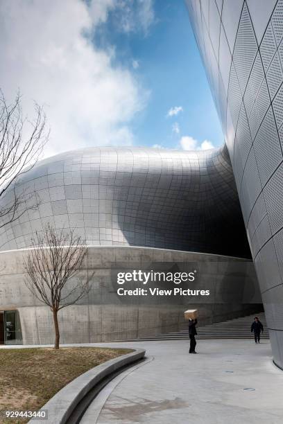 Dongdaemun Design Plaza , Seoul, Korea, South. Architect: Zaha Hadid Architects, 2014. Side elevation showing concrete wall and shapely facade of...