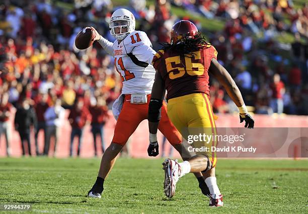 Quarterback Zac Robinson of the Oklahoma State Cowboys throws under pressure from defensive end Christopher Lyle of the Iowa State Cyclones in the...