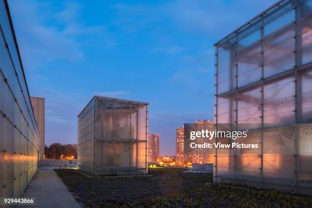 Glass cubes at night with illuminated city beyond. Silesian Museum, Katowice, Poland. Architect: Riegler Riewe Architekten, 2014.