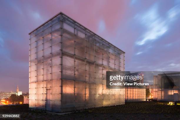 Glass cubes at dusk with illuminated city beyond. Silesian Museum, Katowice, Poland. Architect: Riegler Riewe Architekten, 2014.